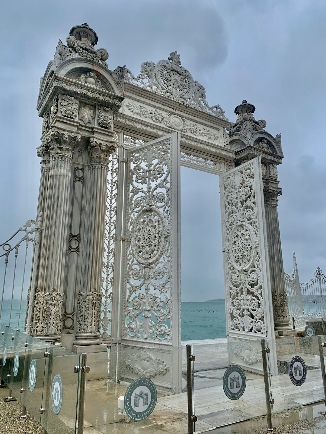 a large white gate sitting next to the ocean